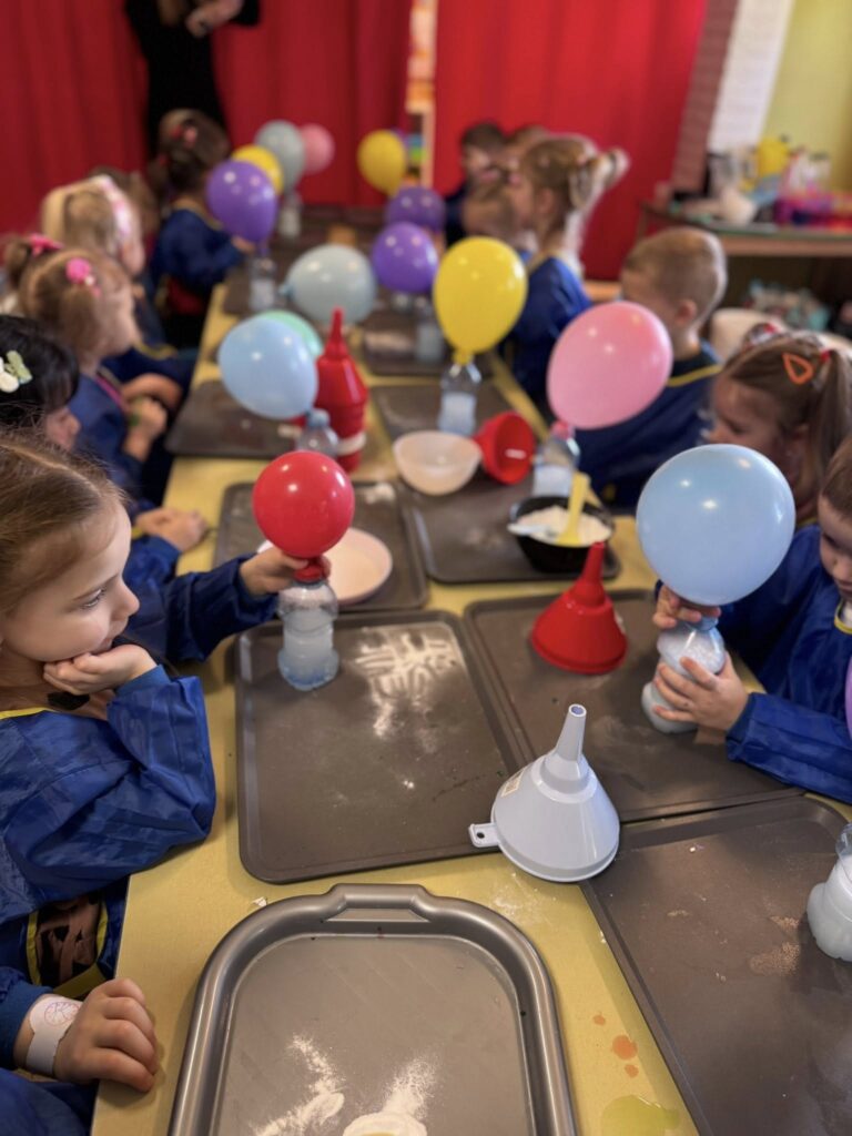 Dzieci na warsztatach w szkole dmuchające balony