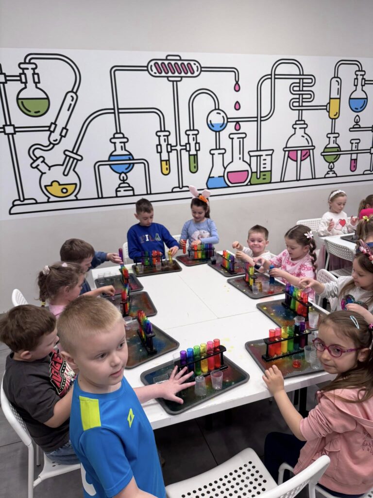 Dzieci w sali kolorowego laboratorium gotowe do zajęć