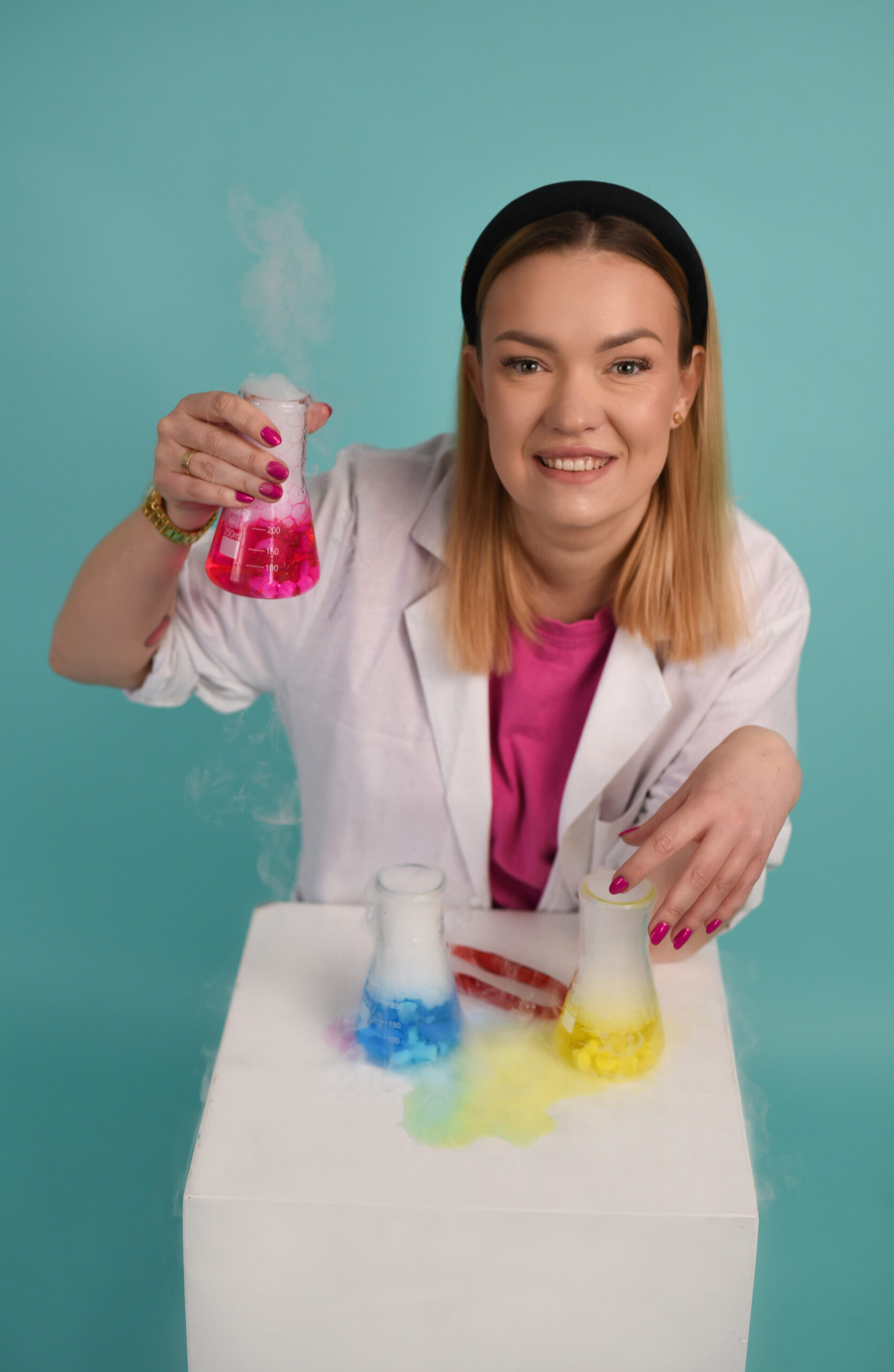 Zdjęcie Marty z kolorowego laboratorium trzymającej kolorowe fiolki